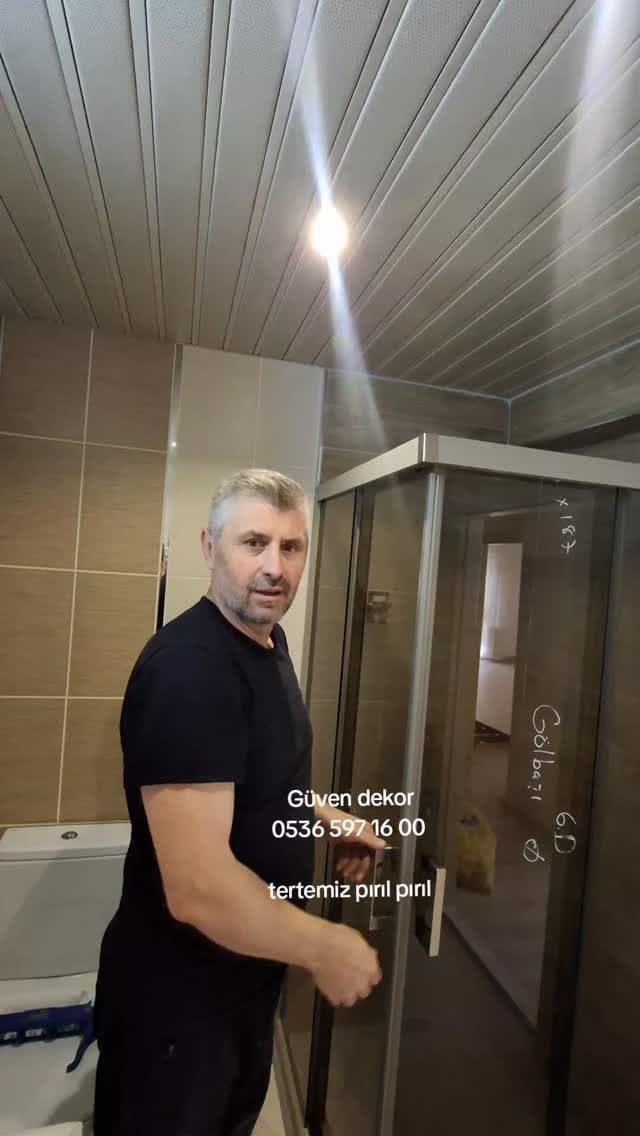 Usta duşakabin montajını tamamlarken