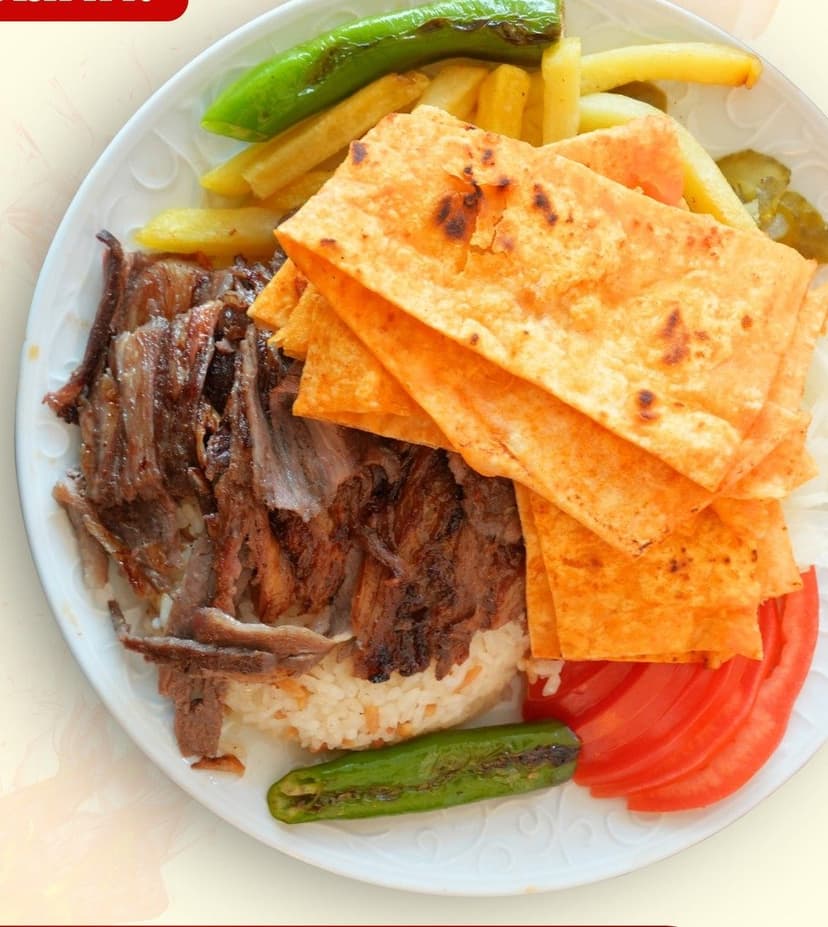Et döner tabak servis — pilav, pide ve közlenmiş biberle
