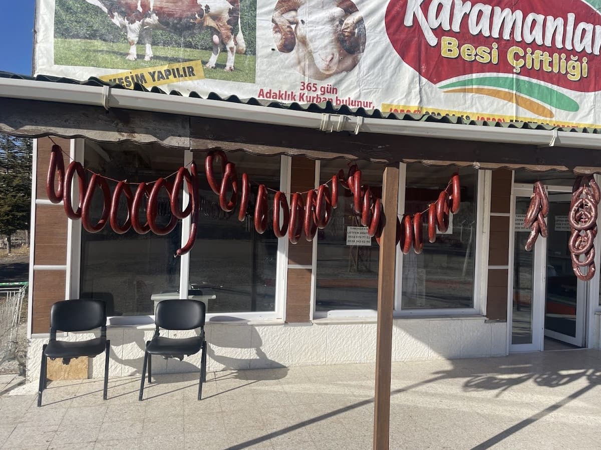 Karamanlar Et dükkân önü — asılı ev yapımı sucuklar ve Karamanlar Besi Çiftliği tabelası