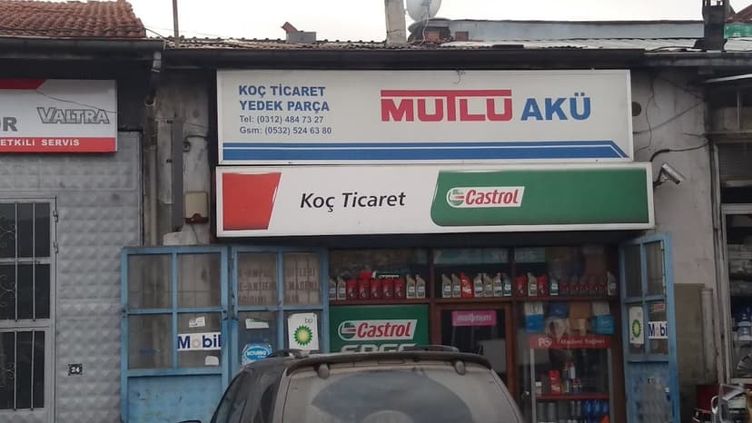 Koç Ticaret mağaza cephesi — Mutlu Akü ve Castrol tabelası (Google Haritalar)