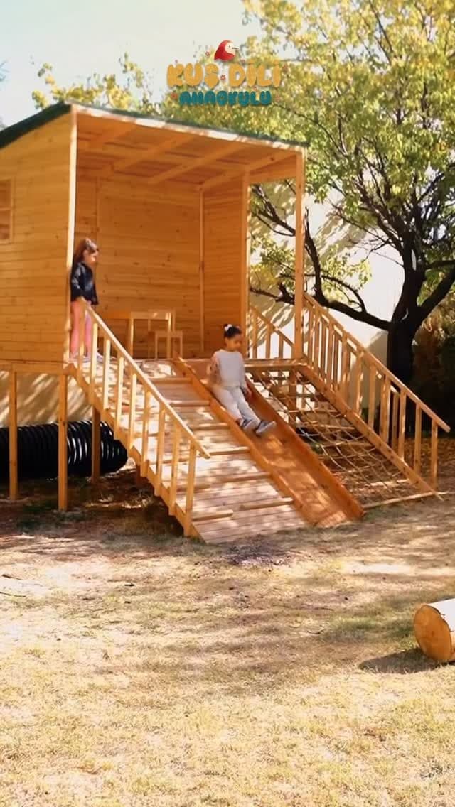 Bahçede ahşap oyun evi ve kaydırak