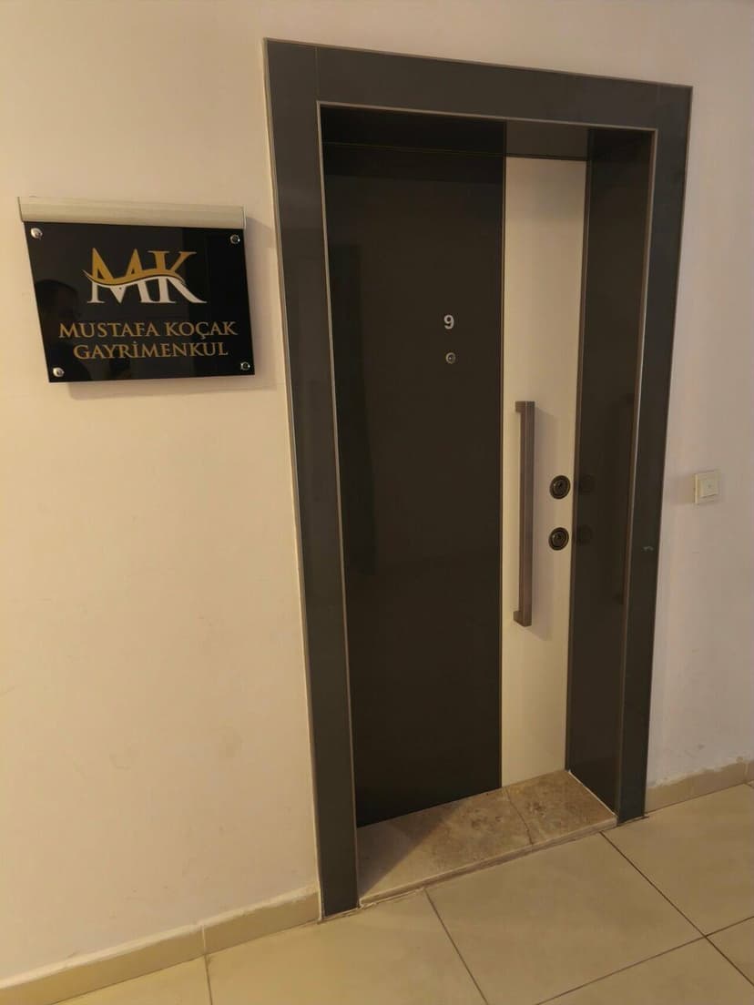 Ofis kapısı ve Mustafa Koçak Gayrimenkul tabelası