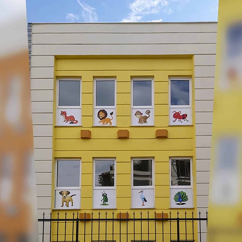 Okul binası — sarı cephe ve renkli sınıf pencereleri