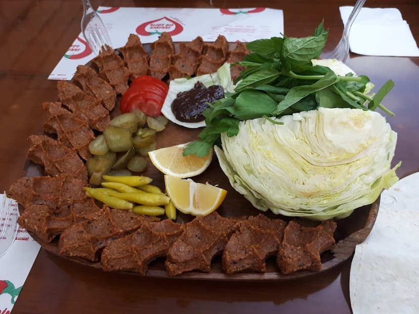 Çiğ köfte porsiyonu, göbek marul ve limon ile