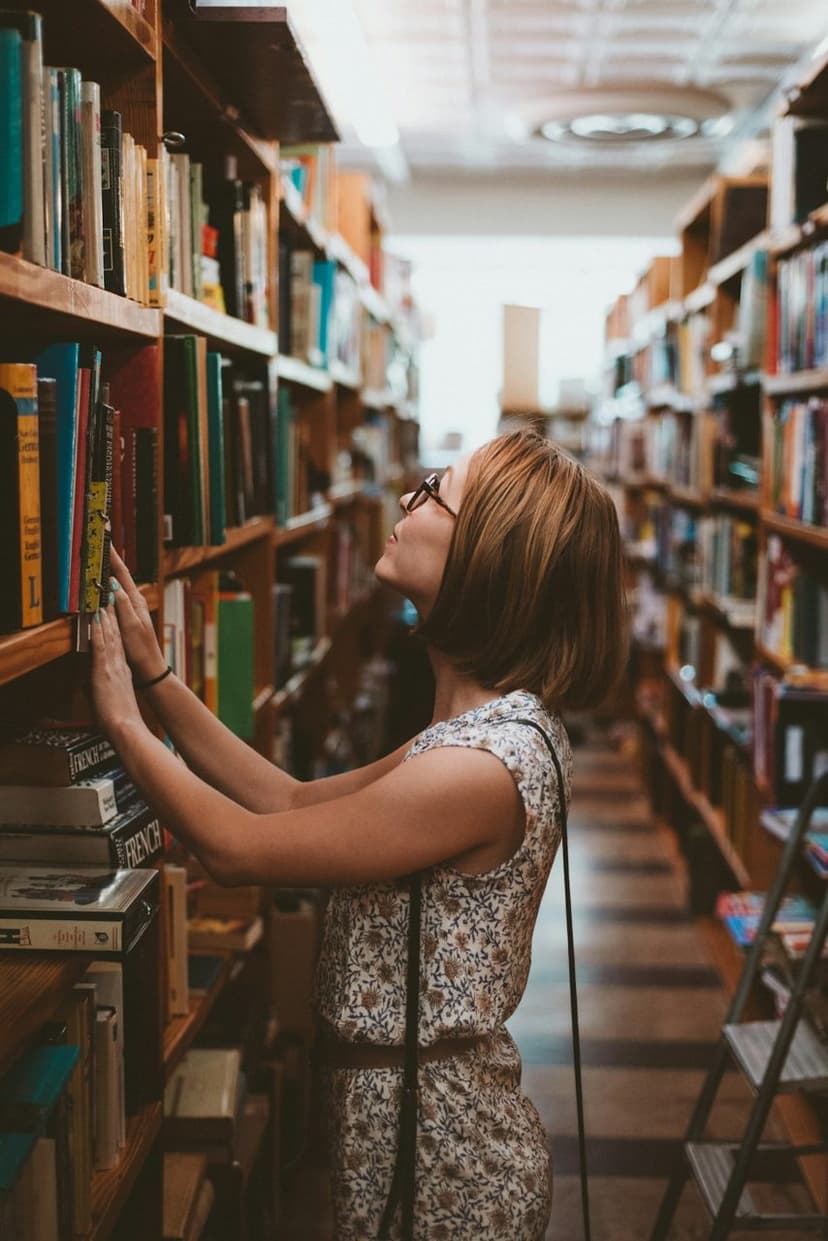 Raflar arasında kitap seçen okur (temsili görsel)