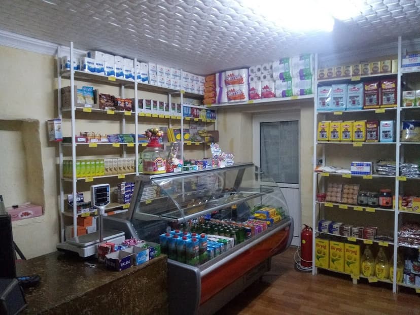 Market içi — raflar, şarküteri reyonu ve soğutucu