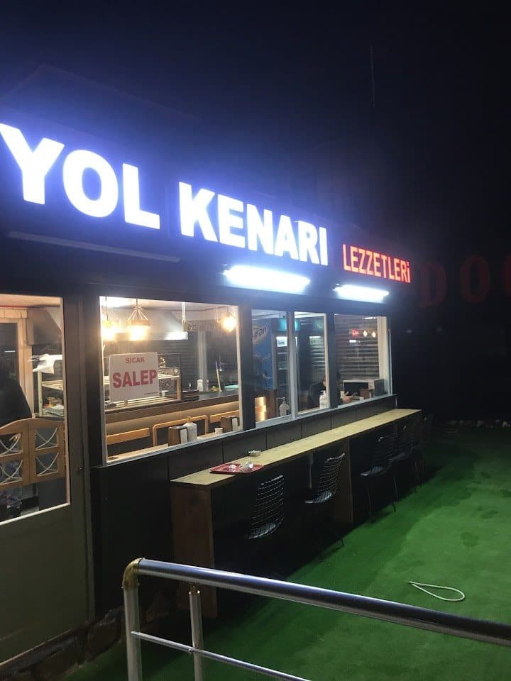 Yol Kenarı Lezzetleri — dükkân cephesi ve sokak oturma alanı (akşam)